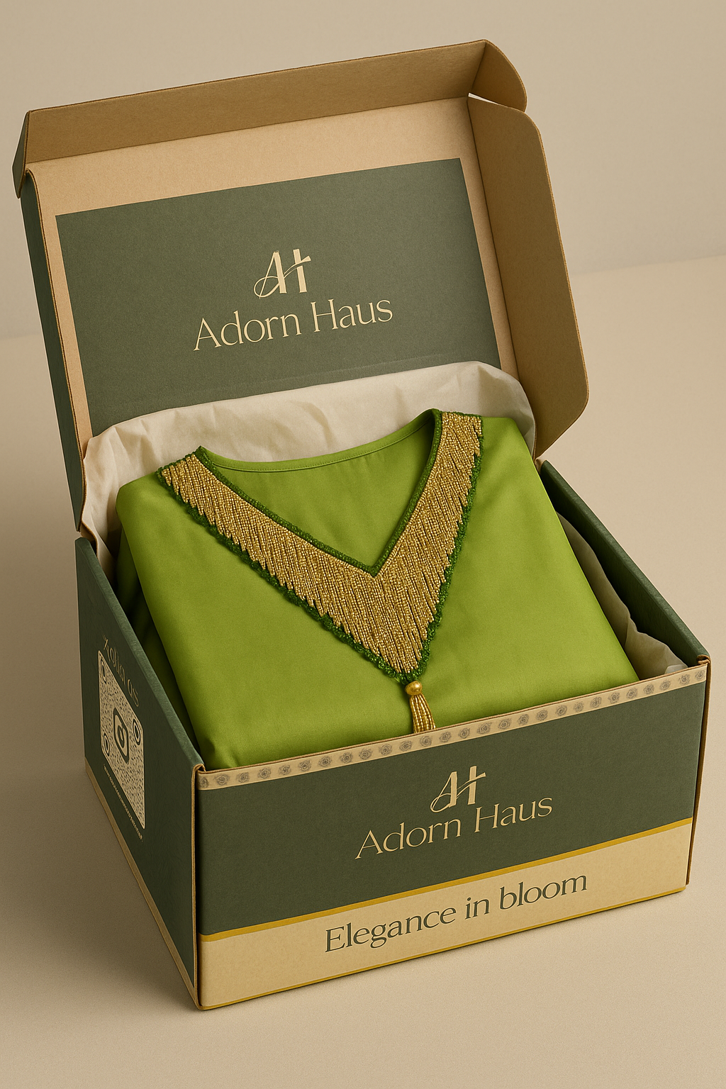 Green garment with gold trim in a 'Adorn Haus' box on a beige background