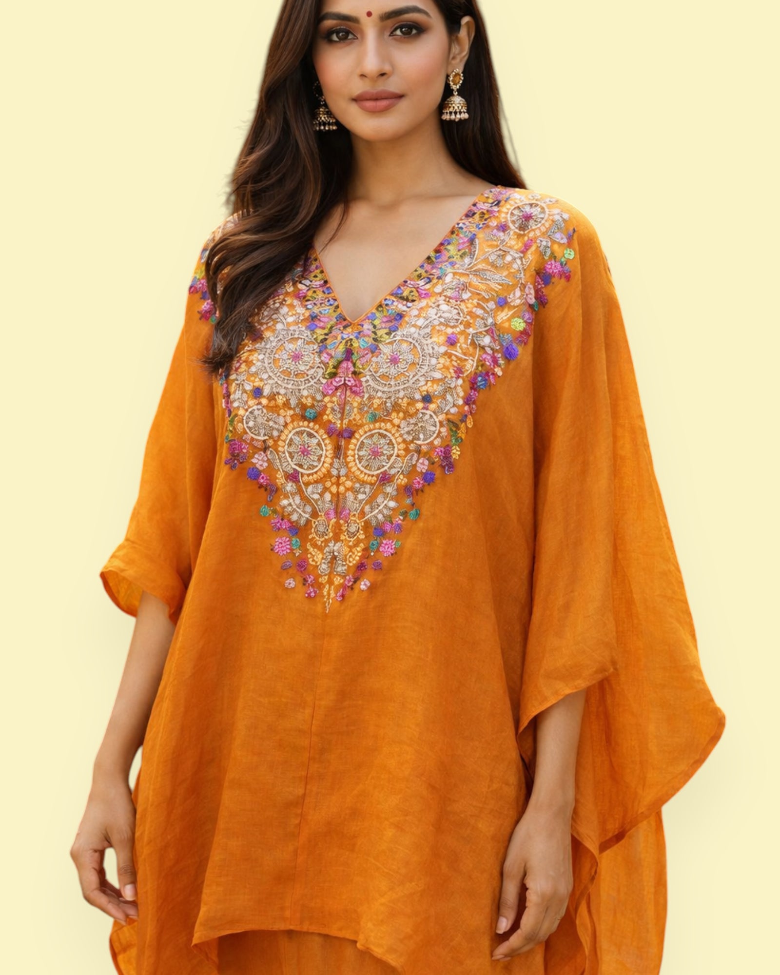 Woman wearing an orange embroidered dress on a light yellow background