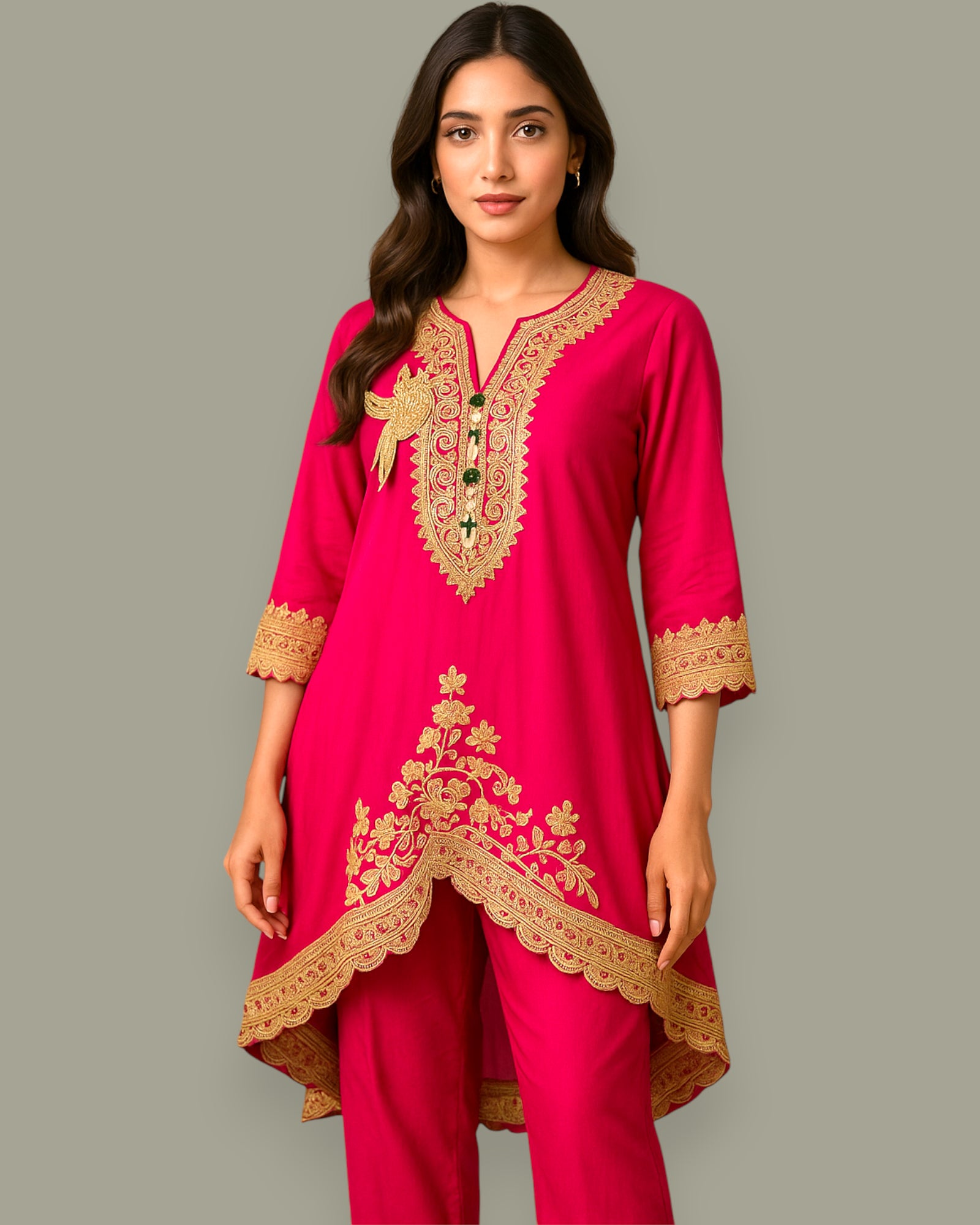 Woman wearing a pink embroidered outfit on a gray background