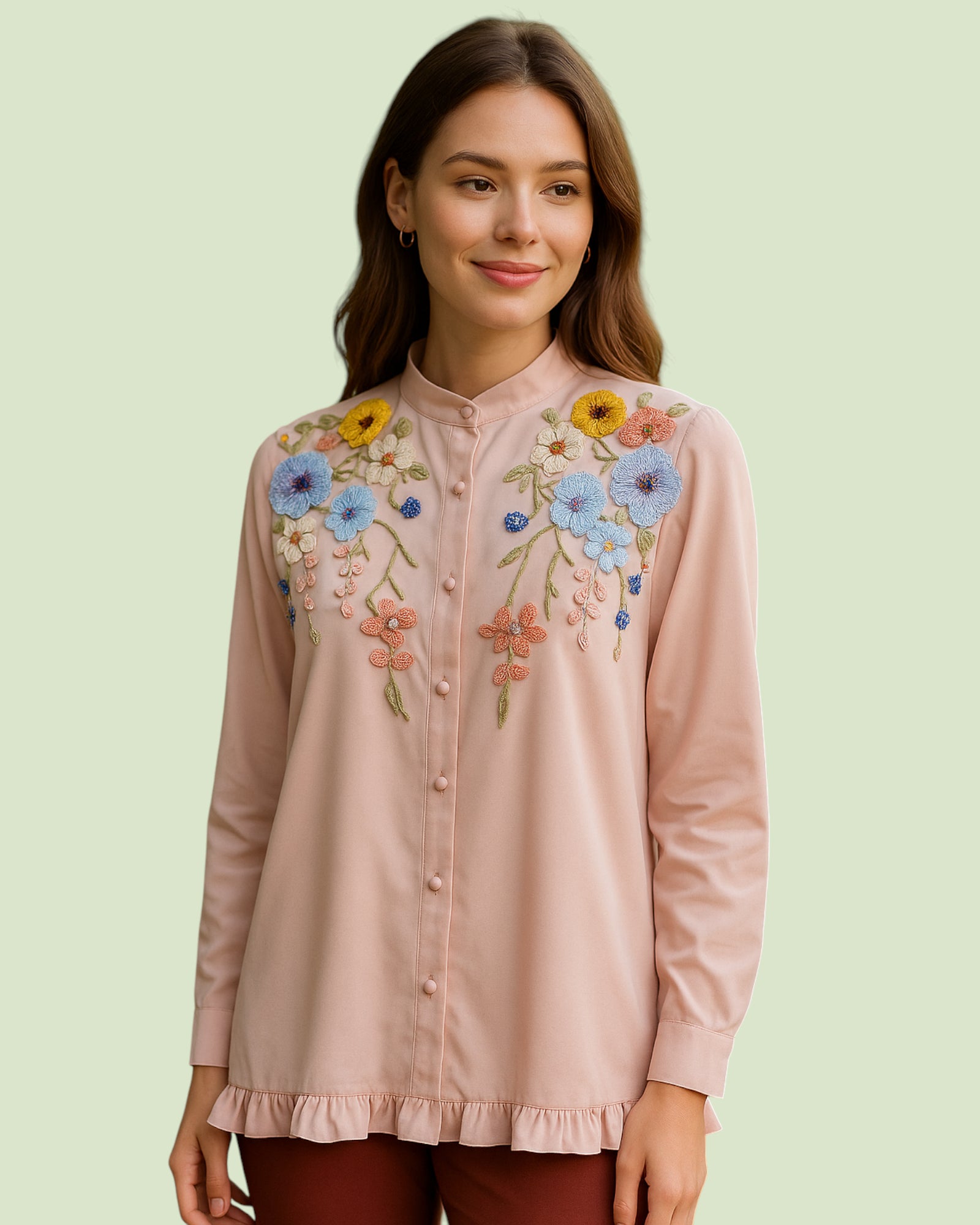 Woman wearing a pink Shirt with floral embroidery on a light green background
