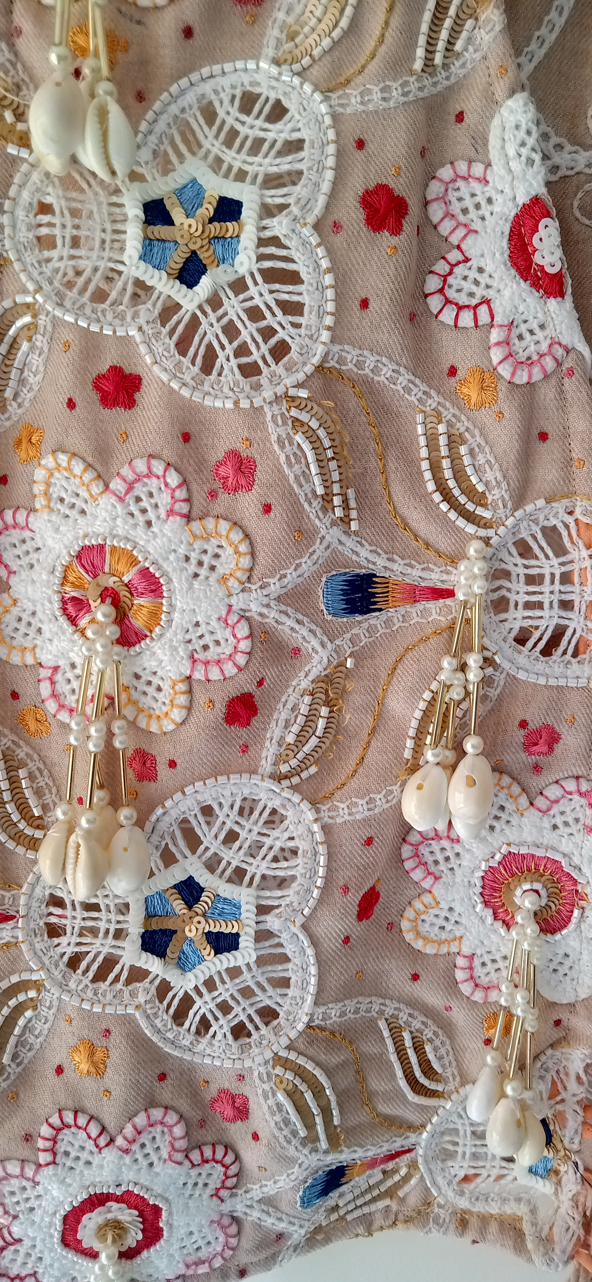 Close-up of a decorative fabric with floral patterns and beads.