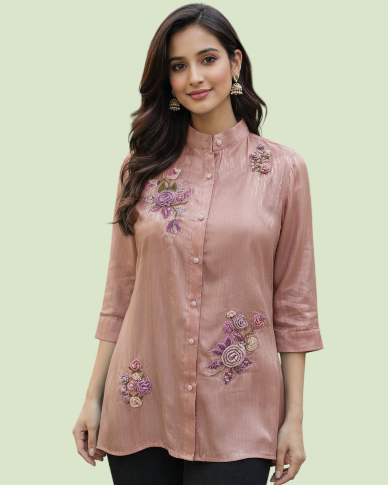 Woman wearing a pink embroidered blouse on a light green background