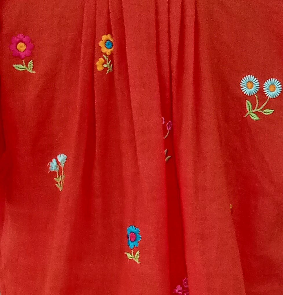 Red fabric with colorful embroidered flowers