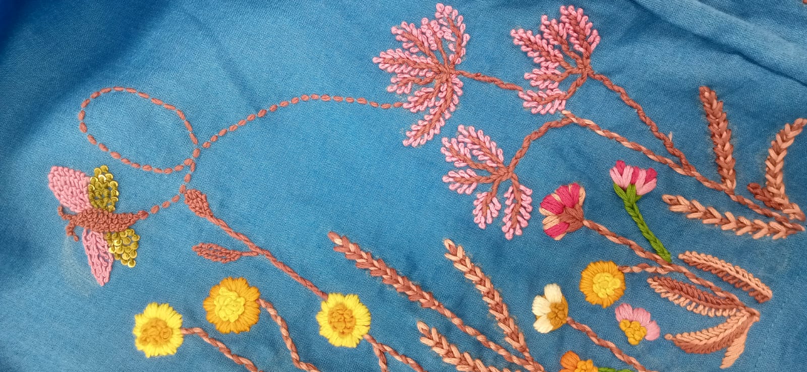 Embroidered floral design on a blue fabric background