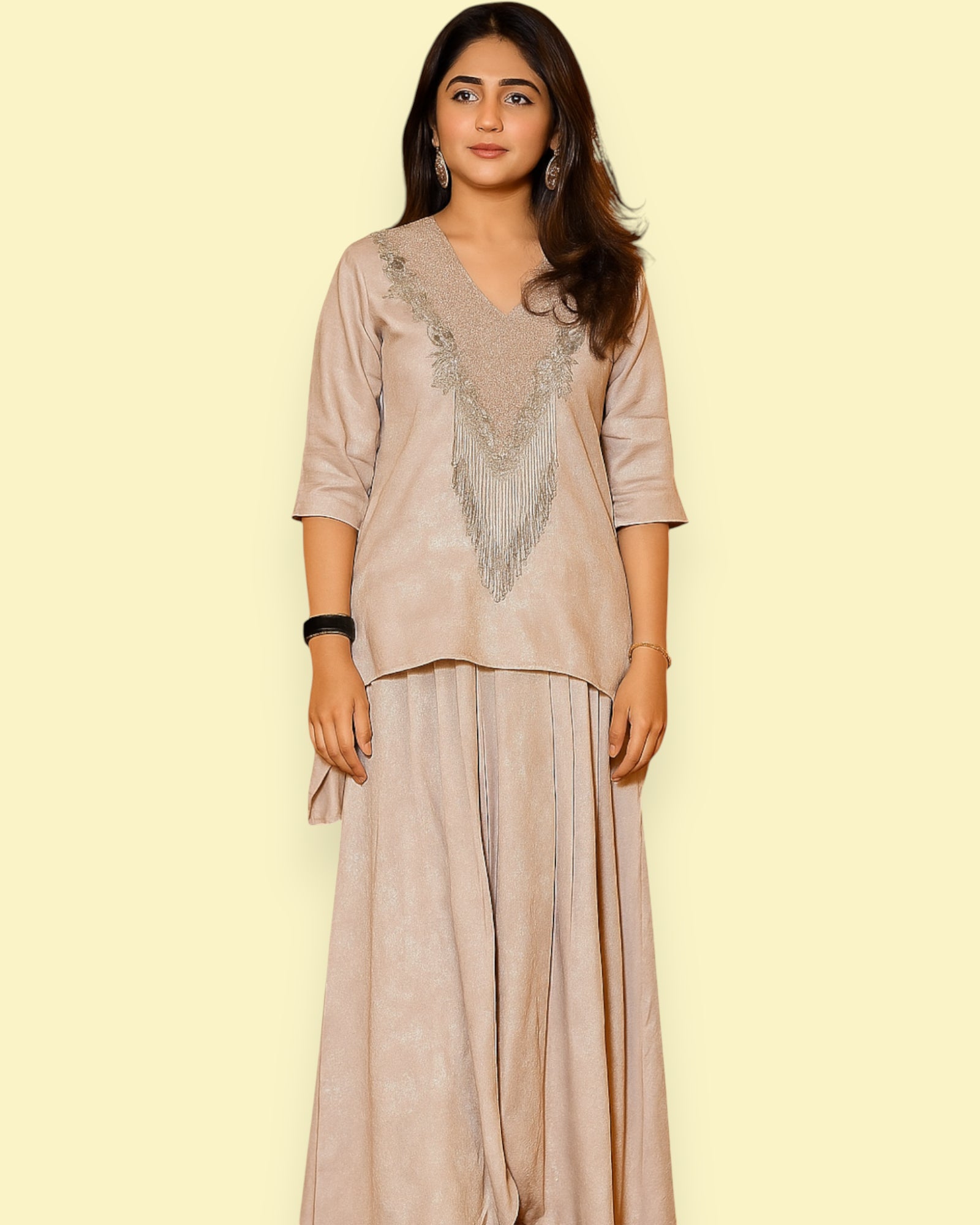 Woman wearing a beige outfit with Embroidery  on a light yellow background