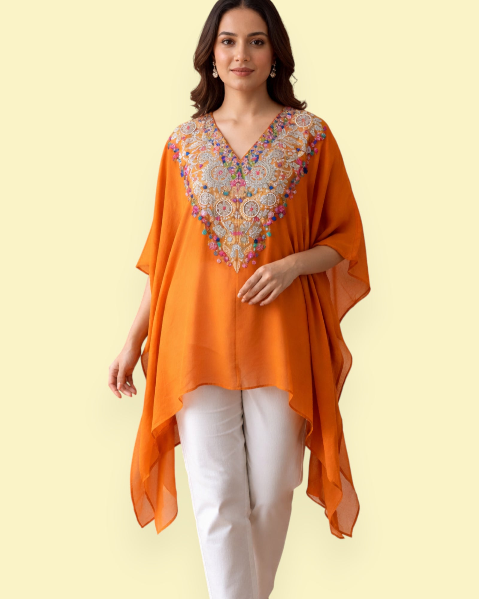 Woman wearing an orange embroidered Kaftan with a plain background