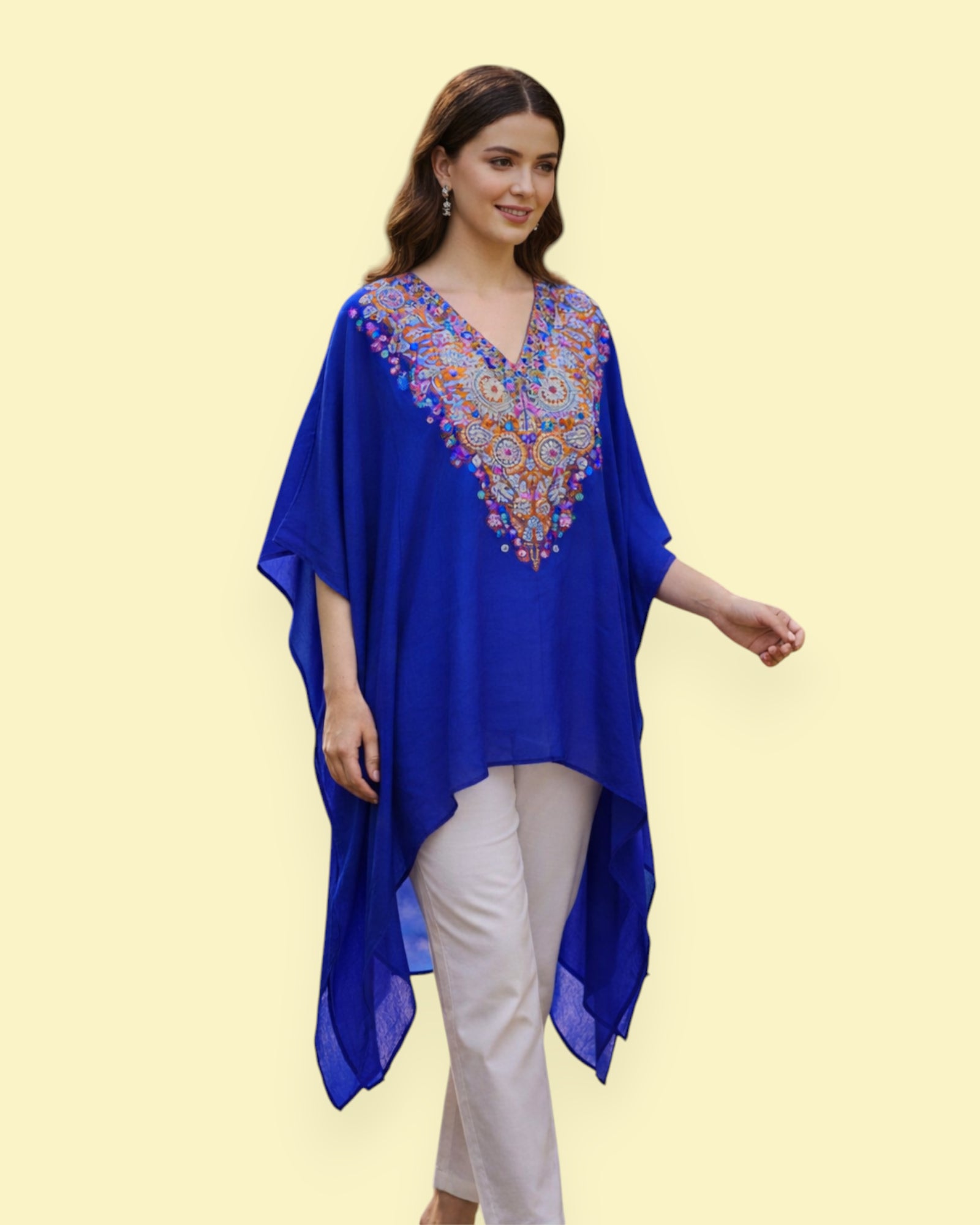 Woman wearing a blue embroidered top with a yellow background