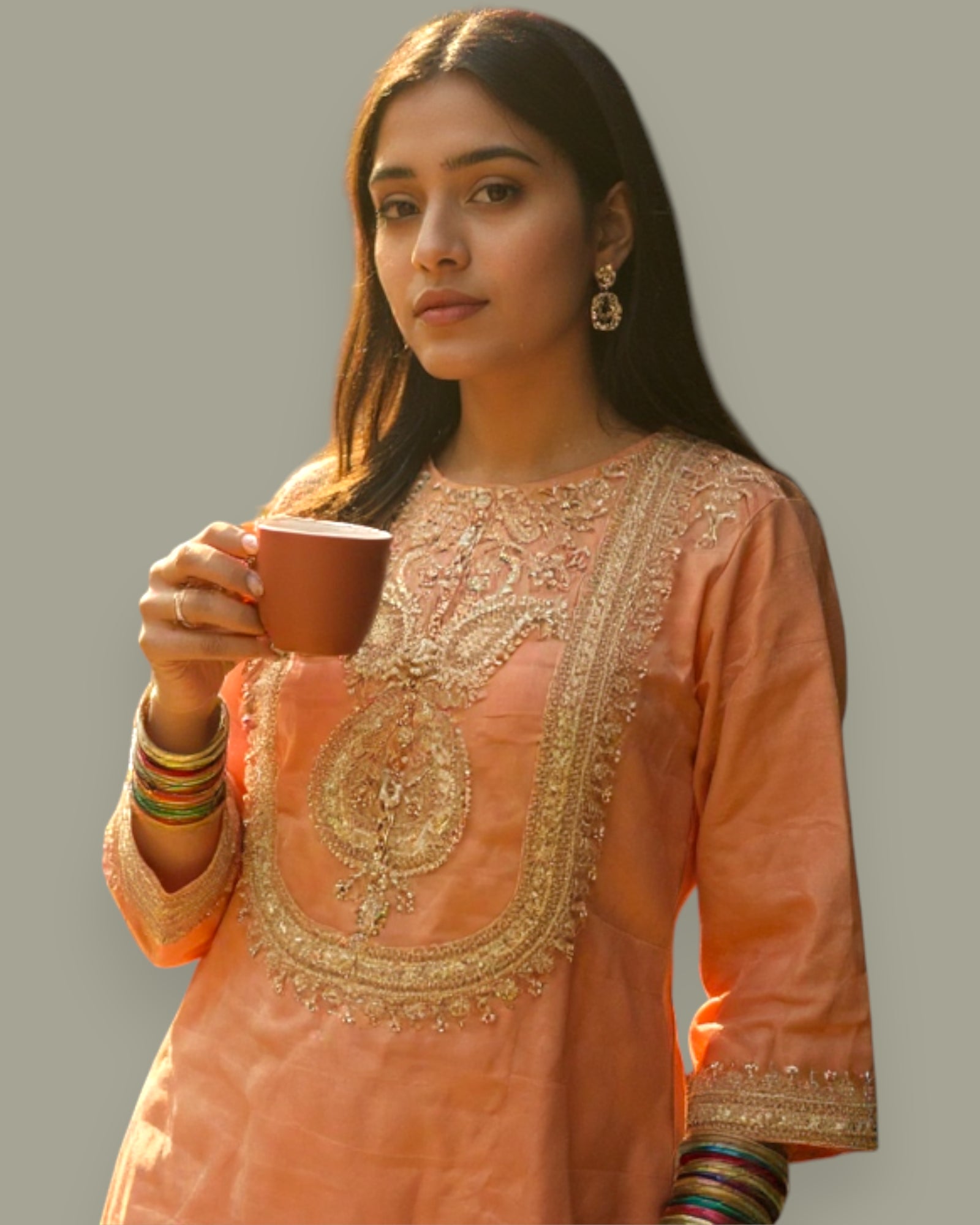 Woman in traditional peach embroidered outfit holding a cup against a neutral background