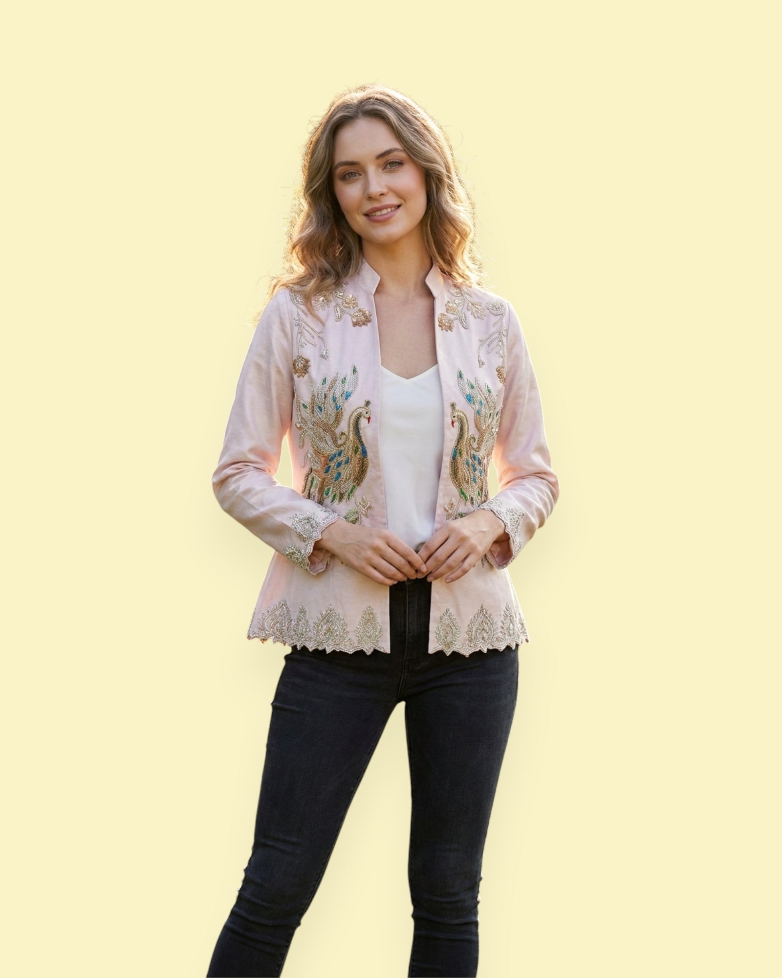Woman wearing a floral embroidered jacket over a white top and black pants on a light yellow background
