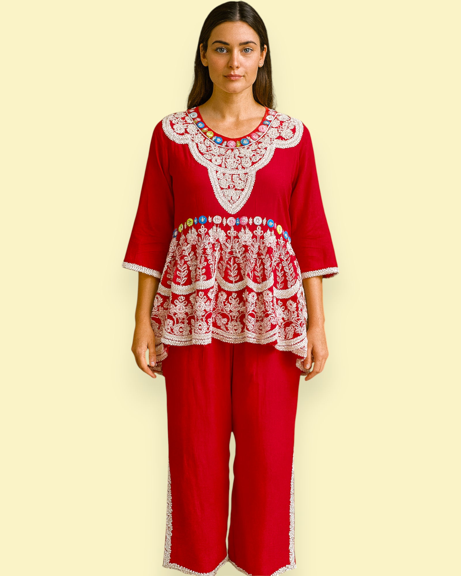 Woman wearing a red outfit with white Embroidery on a beige background