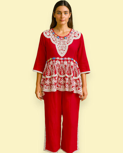 Woman wearing a red outfit with white Embroidery on a beige background