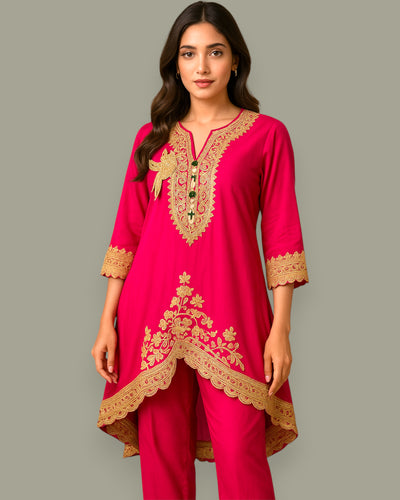 Woman wearing a pink embroidered outfit on a gray background