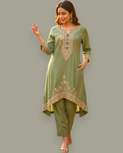 Woman wearing a green embroidered outfit on a gray background