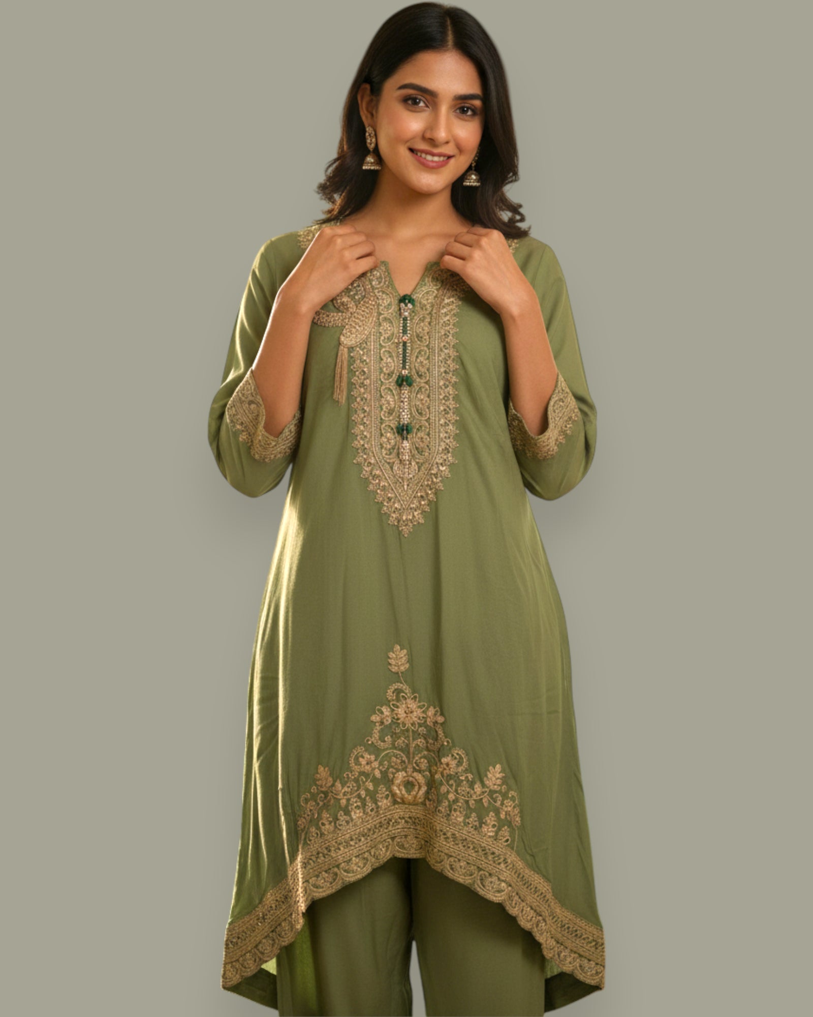 Woman wearing a green embroidered outfit on a gray background