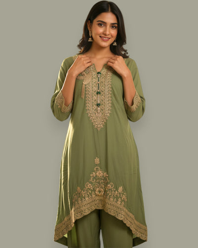 Woman wearing a green embroidered outfit on a gray background