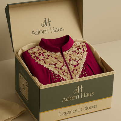 Red embroidered garment in a 'Adorn Haus' box on a beige background