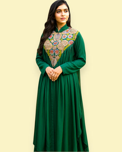 Woman wearing a green dress with floral embroidery on a beige background
