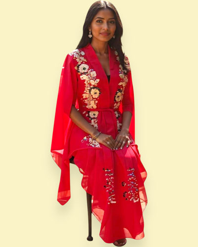 Woman wearing a red dress with floral embroidery on a beige background