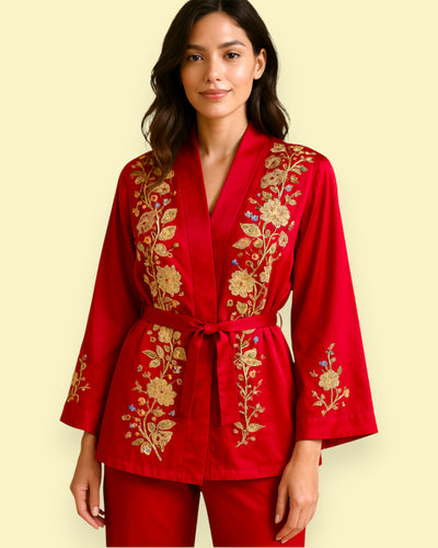 Woman wearing a red embroidered outfit on a beige background