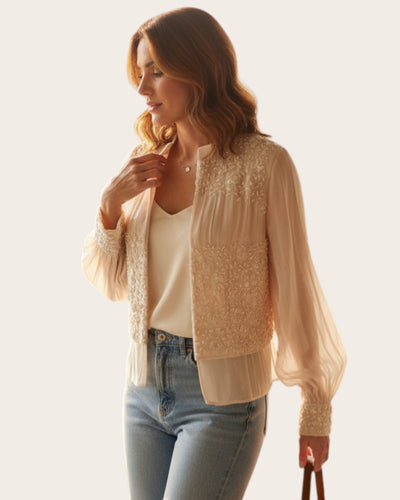 Woman wearing a beige lace Shirt on a plain background