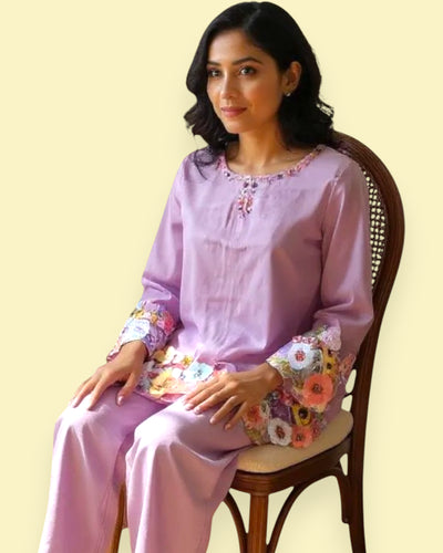 Woman wearing a Purple traditional outfit with floral sleeves on a beige background