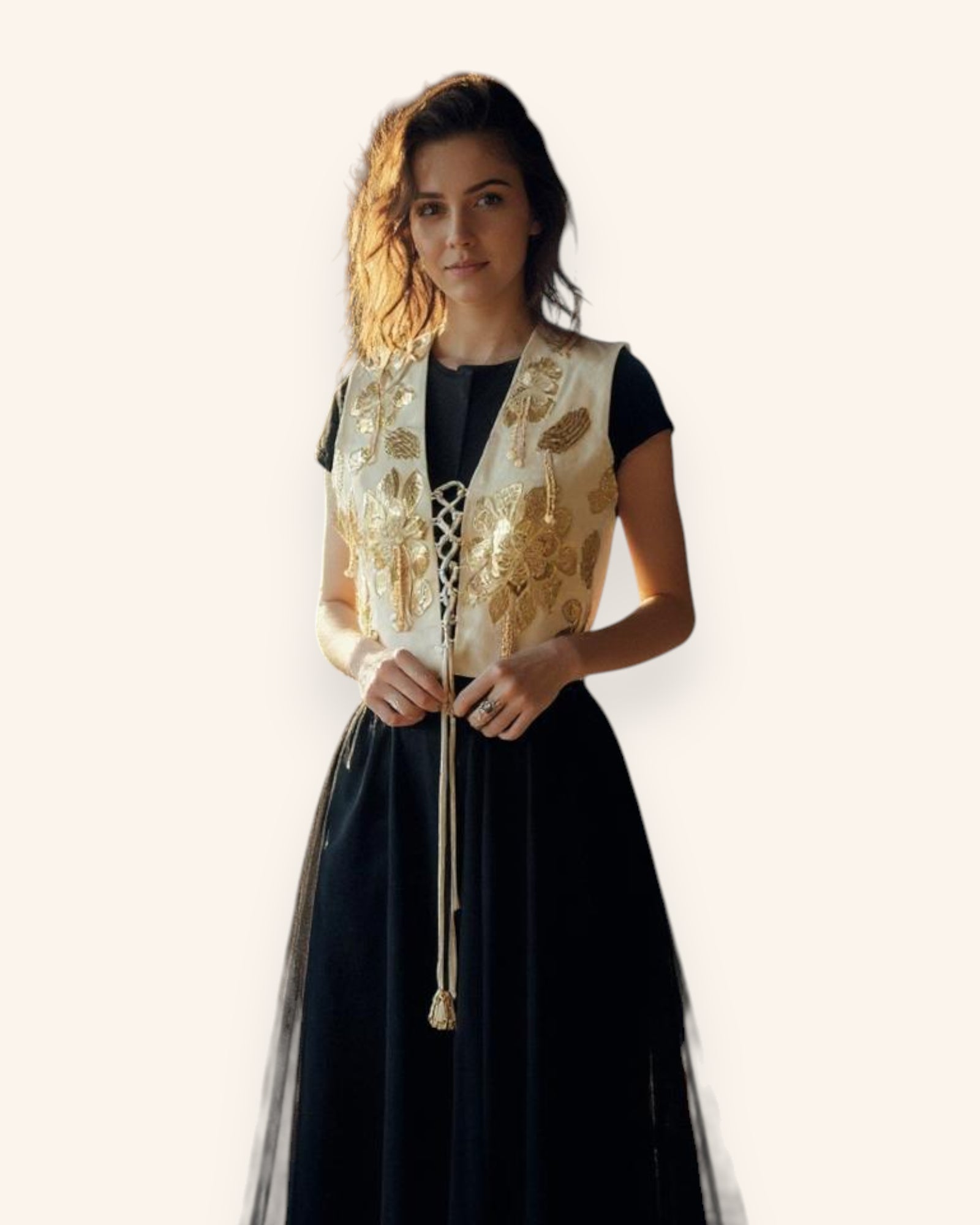 Woman wearing a black dress with a gold embroidered vest on a white background
