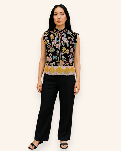 Woman wearing a Embroidery vest over a black top with wide-leg pants on a white background