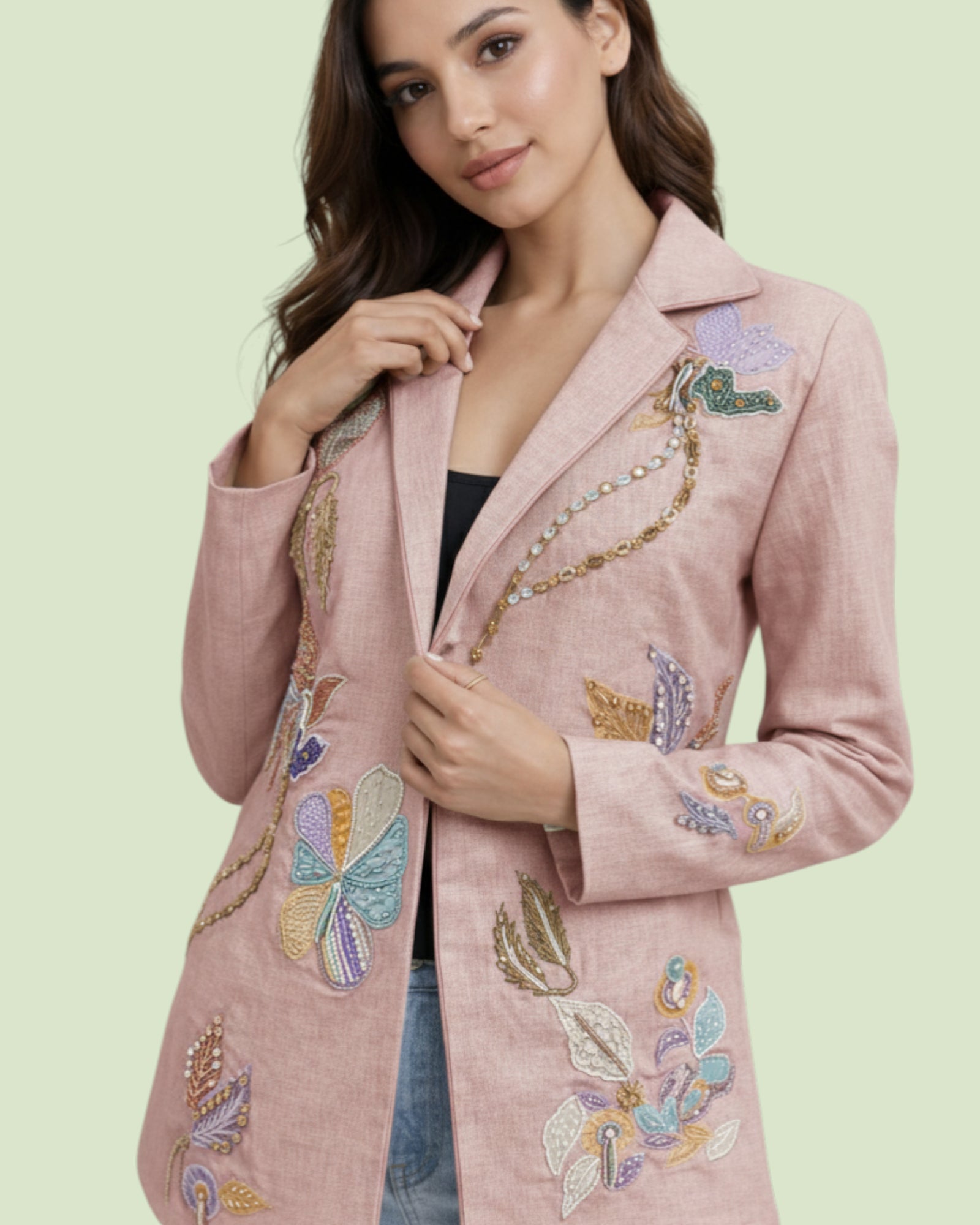 Woman wearing a pink blazer with colorful butterfly embellishments on a light green background