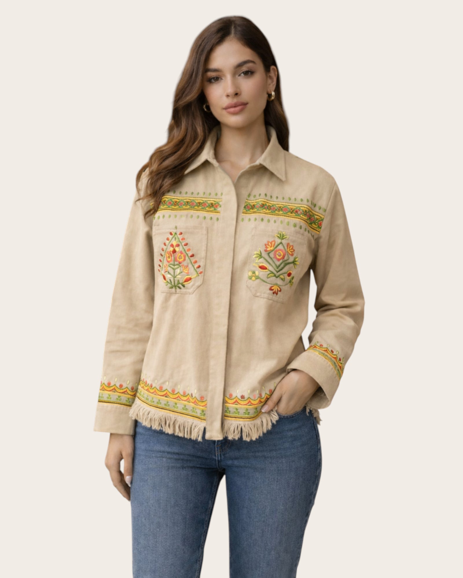 Woman wearing a beige embroidered shirt with floral patterns on a plain background