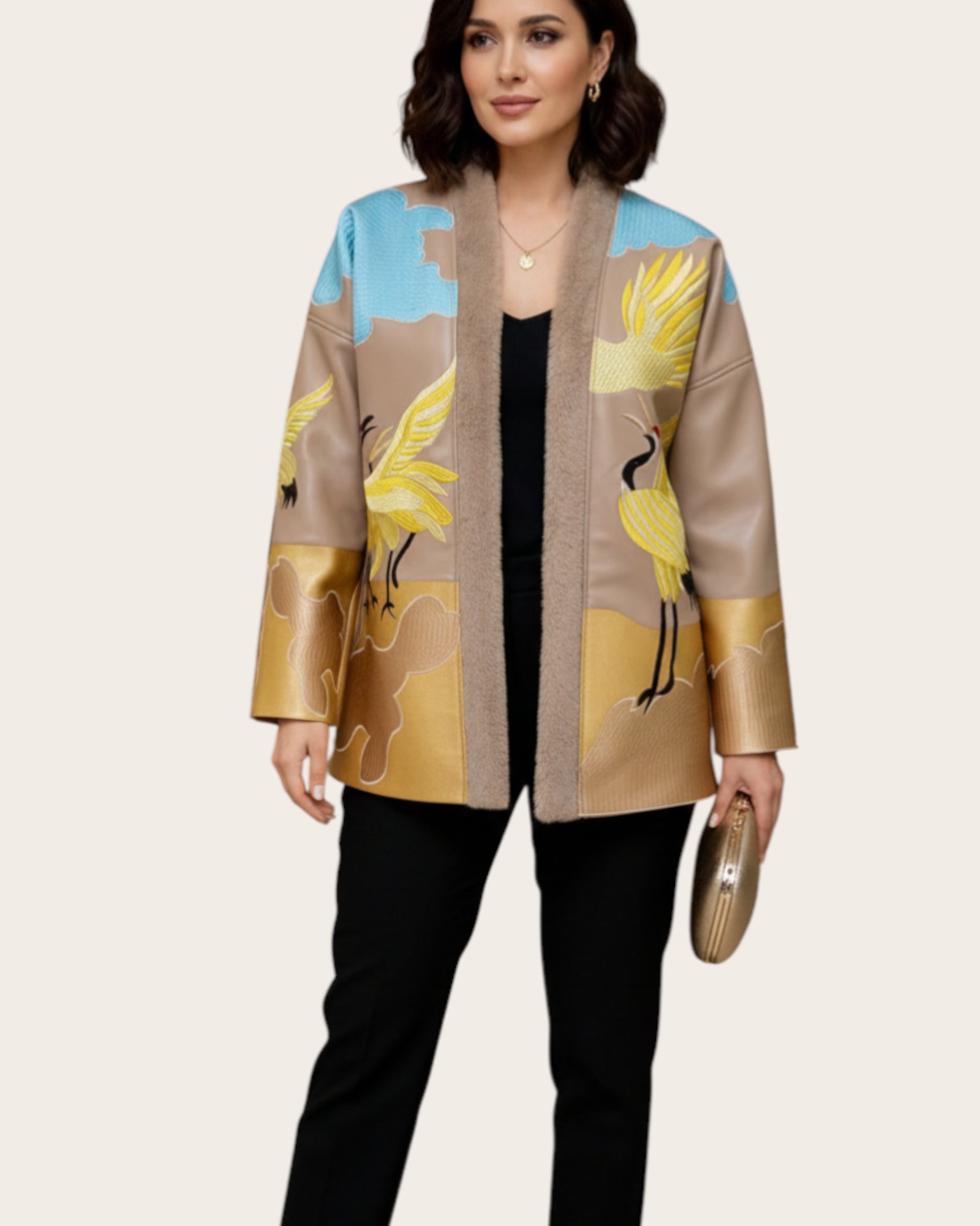 Woman wearing a beige jacket with bird Embroidery designs on a plain background