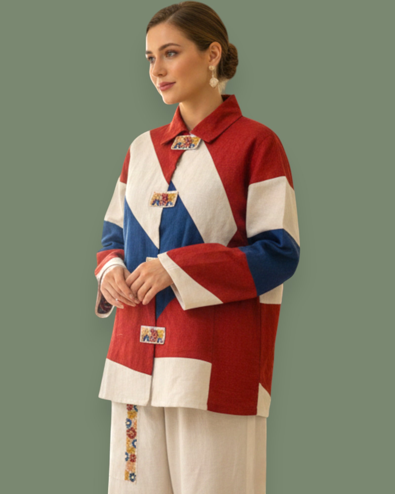 Woman wearing a colorful jacket with geometric embroidery  on a green background
