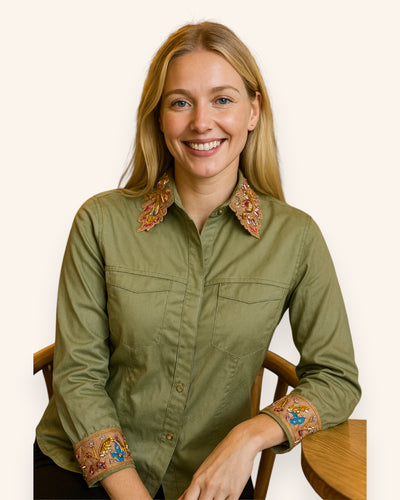 Woman wearing a green shirt with embroidered details on a white background