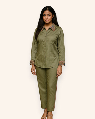 Woman wearing an olive green outfit with lace details on a white background