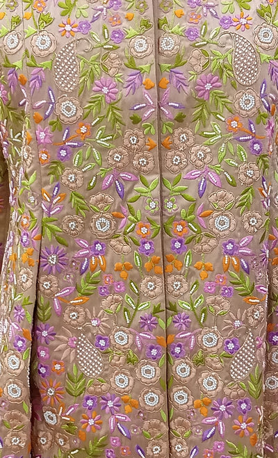 Close-up of a fabric with intricate floral embroidery in various colors.