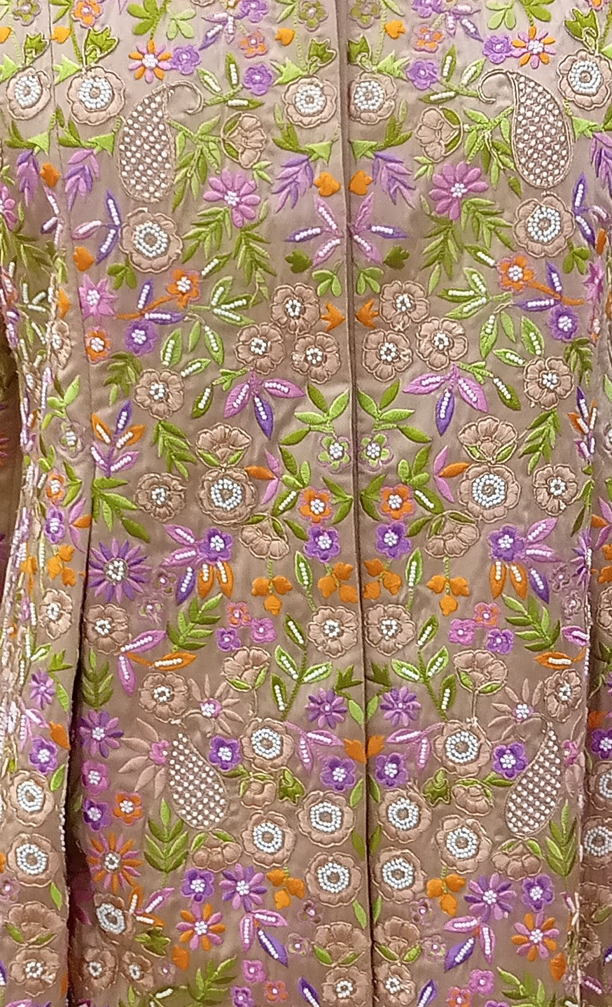 Close-up of a fabric with intricate floral embroidery in various colors.