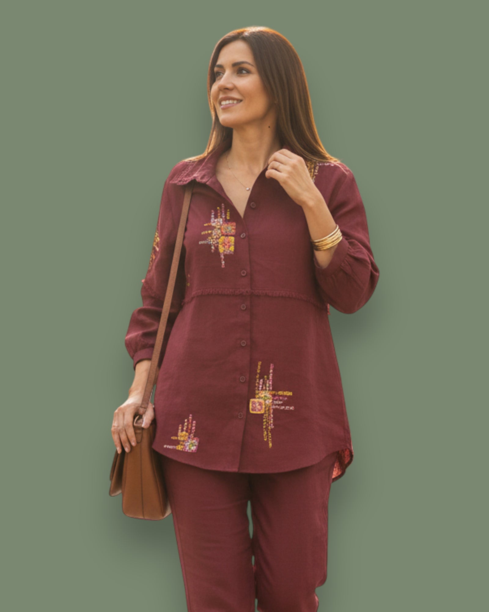 Woman wearing a Red outfit with embroidery against a green background