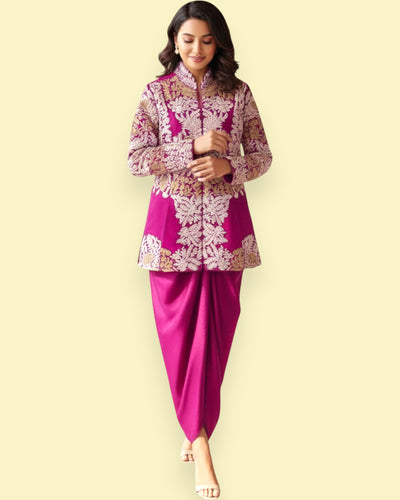 Woman wearing a pink traditional outfit with intricate patterns on a beige background