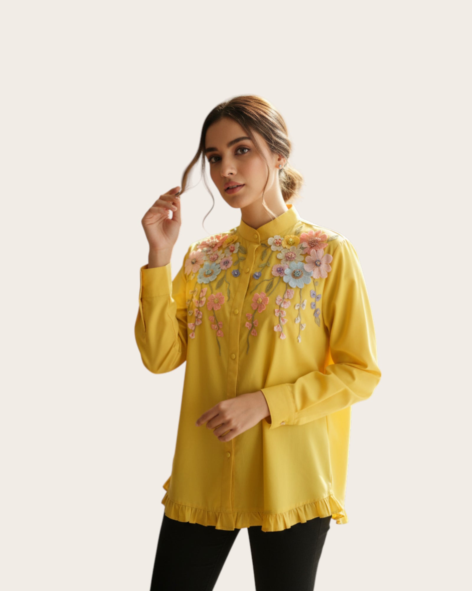 Woman wearing a yellow Shirt with floral embroidery on a plain background